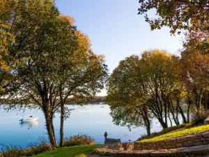 un hombre de pie junto a un lago con un barco en Maison Locoal-Mendon, 5 pièces, 7 personnes - FR-1-397-69, en Locoal-Mendon