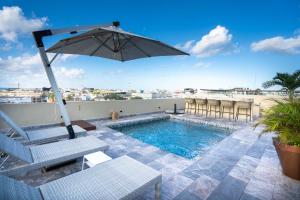 un patio avec un parasol et une piscine dans l'établissement Singular by Andiani Travel, à Playa del Carmen