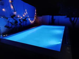 una piscina azul en una habitación oscura con luces en Casa Vacanze Noemi, en Riposto