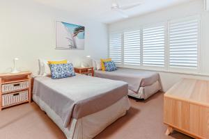 1 Schlafzimmer mit 2 Betten und einem Fenster in der Unterkunft Comfortable & stylish with rooftop spa in Sunshine Beach
