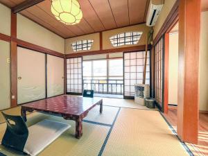 a room with a table in a room with windows at Kobori Ryokan in Hirosaki