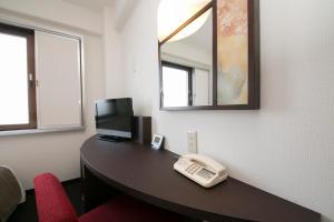 a office cubicle with a desk with a computer and a phone at Urban Hotel Kyoto in Kyoto +16 photos