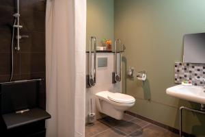 La salle de bains est pourvue de toilettes, d'un lavabo et d'une douche. dans l'établissement Leonardo Royal Hotel Amsterdam, à Amsterdam