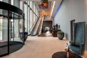 a hallway with an escalator in a building at Leonardo Royal Hotel Amsterdam in Amsterdam
