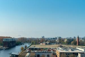 a view of a city with a river and buildings at Leonardo Royal Hotel Amsterdam in Amsterdam