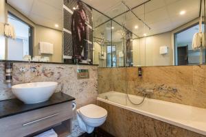 a bathroom with a sink and a tub and a toilet at Leonardo Boutique Museumhotel in Amsterdam