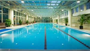 uma grande piscina interior com água azul em DoubleTree by Hilton Beijing em Pequim