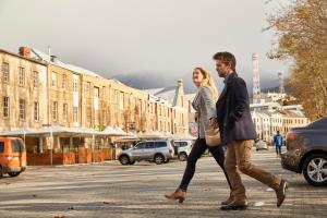 un hombre y una mujer caminando por una calle en RACV Hobart Hotel en Hobart