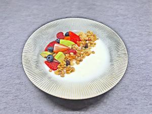 a white plate with fruit and vegetables on it at Kaiyue Hotel Christ's Church, Qingdao in Qingdao