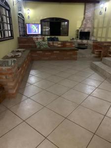 um quarto amplo com televisão e piso em azulejo em Recanto dos Passáros Penedo RJ em Penedo