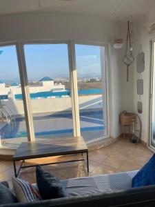 uma sala de estar com uma mesa e uma grande janela em Chemsy Loft em Marina Smir