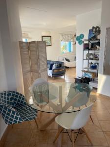 Chemsy Loft في مارينا سمير: غرفة معيشة مع طاولة وكراسي زجاجية
