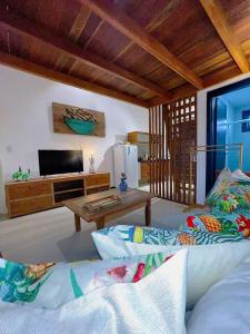 ein Wohnzimmer mit einem Sofa und einem Tisch in der Unterkunft Estudio Top Praia do Forte in Mata de Sao Joao