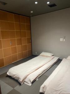 a room with two beds in a room with a wall at 山水之家 in Otsu