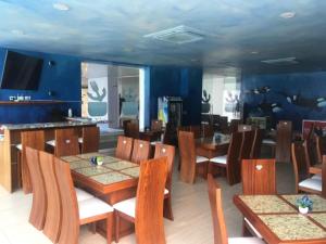 ein Restaurant mit Holztischen und -stühlen und blauen Wänden in der Unterkunft Apartment (Grand Diamond Beach) Tonsupa in Tonsupa