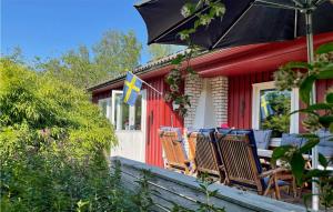 czerwony dom z krzesłami i parasolem na ganku w obiekcie Stunning Home In Fagerfjll With Wifi w mieście Djupvik
