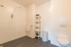 a white bathroom with a toilet and a shower at Leonardo Hotel Papendrecht in Papendrecht