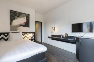 Habitación de hotel con cama y TV de pantalla plana. en Leonardo Hotel Lelystad City Center en Lelystad