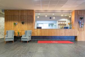 una sala d'attesa con due sedie e un tappeto rosso di Leonardo Hotel Lelystad City Center a Lelystad