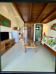 ein Wohnzimmer mit einem Sofa und einem Couchtisch in der Unterkunft Estudio Top Praia do Forte in Mata de Sao Joao