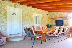 ein Esszimmer mit einem Holztisch und Stühlen in der Unterkunft Villa Manuela in Hrvace