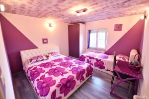 2 Betten in einem Zimmer mit lila und weißen Wänden in der Unterkunft Villa Manuela in Hrvace