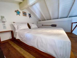 1 dormitorio con 1 cama blanca en una habitación en Estudio Top Praia do Forte en Mata de Sao Joao