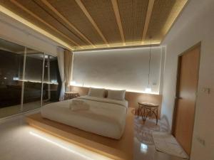 Postel nebo postele na pokoji v ubytování Taris River Cottage, Rachaburi
