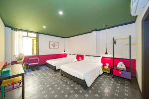 une chambre d'hôtel avec deux lits et un bureau dans l'établissement BÁNH INN, à Hue