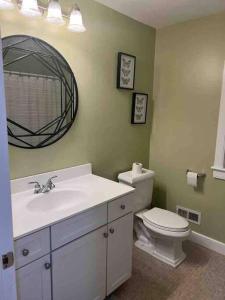 uma casa de banho com um lavatório, um WC e um espelho. em Home in Oak Bluffs em Oak Bluffs
