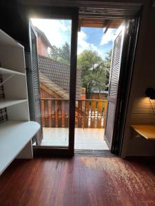 Cette chambre dispose d'une porte s'ouvrant sur un balcon. dans l'établissement Pousada do Mel, à Gramado