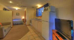 a kitchen with a white refrigerator and a tv at Sandy Hollow Tourist Retreat in Sandy Hollow