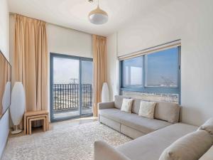 uma sala de estar com um sofá e janelas grandes em 3BDRM Near Metro for Family&Group em Dubai