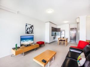 a living room with a couch and a tv at Story Apartments in Brisbane