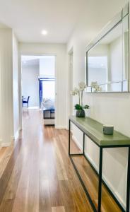 a living room with a table and a mirror at Pinecone Lodge - Luxury 4BR Home l EV Charger l Fire Pit l WiFi l BBQ l 4 Car Garage in Jindabyne