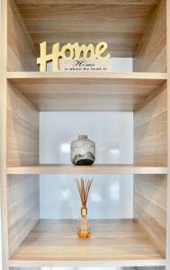 a wooden shelf with a home sign on it at Pinecone Lodge - Luxury 4BR Home l EV Charger l Fire Pit l WiFi l BBQ l 4 Car Garage in Jindabyne