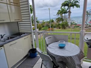 a balcony with a table and a view of the ocean at appartement spacieux vue sur mer in La Trinité