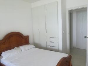 sypialnia z łóżkiem z drewnianym zagłówkiem w obiekcie Apartment (Grand Diamond Beach) Tonsupa w mieście Tonsupa