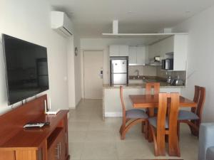eine Küche und ein Esszimmer mit einem Tisch und einem TV in der Unterkunft Apartment (Grand Diamond Beach) Tonsupa in Tonsupa