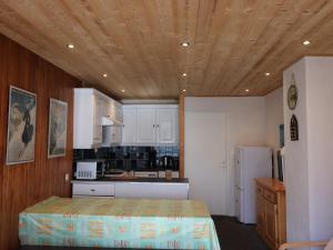 a kitchen with white cabinets and a wooden ceiling at Appartement Tignes, 3 pièces, 6 personnes - FR-1-502-484 in Tignes