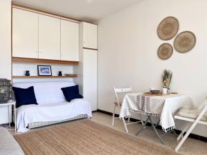 um quarto com uma cama com almofadas azuis e uma mesa em Appartement Bormes-les-Mimosas, 1 pièce, 3 personnes - FR-1-251-494 em Bormes-les-Mimosas