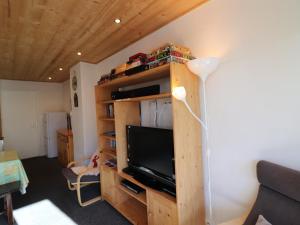 ein Wohnzimmer mit einem TV auf einem hölzernen Bücherregal in der Unterkunft Appartement Tignes, 3 pièces, 6 personnes - FR-1-502-484 in Tignes