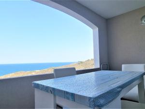 una mesa y sillas con vistas al océano en Appartement Banyuls-sur-Mer, 2 pièces, 4 personnes - FR-1-309-373, en Banyuls-sur-Mer