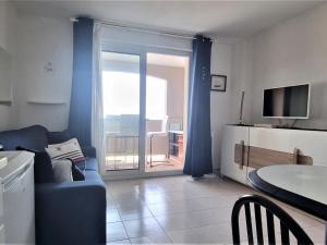 sala de estar con sofá azul y puerta corredera de cristal en Appartement Banyuls-sur-Mer, 2 pièces, 4 personnes - FR-1-309-373, en Banyuls-sur-Mer