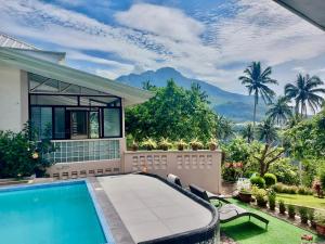 a villa with a swimming pool and a house at Shrivasta Cottages in Abu