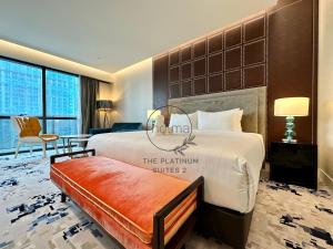 ein Hotelzimmer mit einem großen Bett und einem Stuhl in der Unterkunft The Platinum 2 Kuala Lumpur by HOLMA in Kuala Lumpur