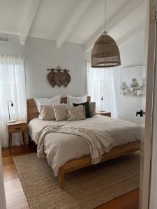 um quarto com uma cama grande e um pendente em Casa Rossi - coastal gem only 300 metres from the beautiful Red Rocks beach - Cowes, Phillip Island em Cowes