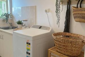 uma lavandaria com uma máquina de lavar roupa e um lavatório em Casa Rossi - coastal gem only 300 metres from the beautiful Red Rocks beach - Cowes, Phillip Island em Cowes