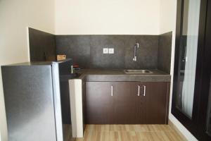 a kitchen with a sink and a refrigerator at Eddys Cottages & Villa in Legian