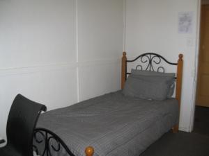 sypialnia z łóżkiem z szarą kołdrą w obiekcie Australian Hotel Winton Budget Hotel Accommodation w mieście Winton